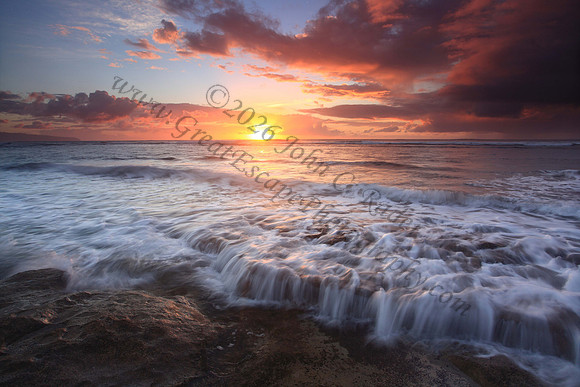 Waves wash North Shore at sunset Oahu Hawaii
