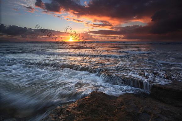 Waves wash North Shore at sunset Oahu Hawaii