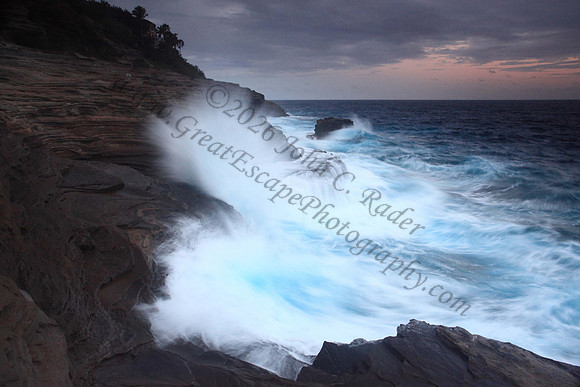 Waves crash on cliffs spitting caves explosions sunset splashing Oahu Hawaii