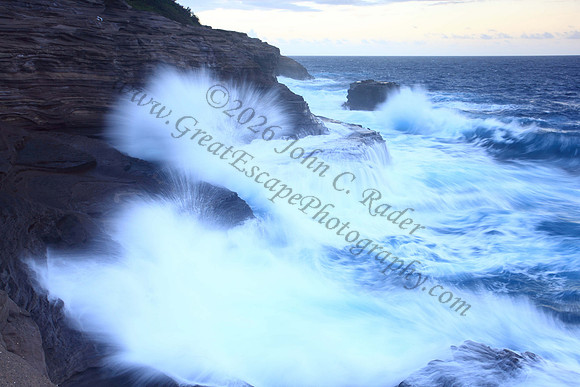 Waves crash on cliffs spitting caves explosions sunset splashing Oahu Hawaii